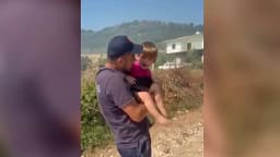 Momenti kur zjarrfikësi qetëson fëmijën e trembur nga zjarret në Mallakastër, evakuohen banorët Momenti kur zjarrfikësi qetëson fëmijën e trembur nga zjarret në Mallakastër, evakuohen banorët